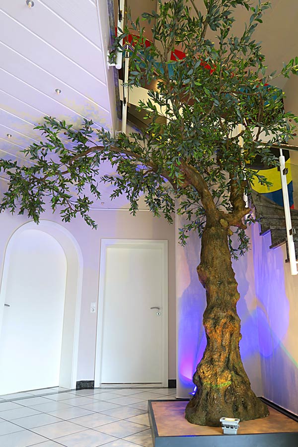 Großer Kunstbaum (Olive) als Dekoration in einem Treppenhaus